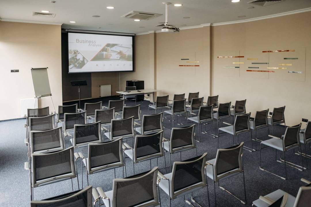 Sala corsi vuota, con le sedie in file davanti allo schermo